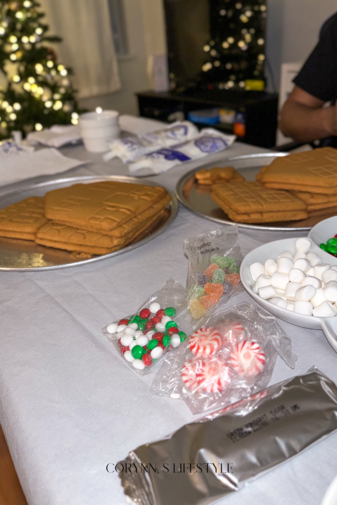 Photo of gingerbread house cookies, marshmallows, candy, and white icing.